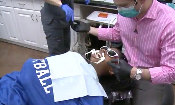 Orthodontist at Houston Orthodontic Specialists examining a patient as they lay in a dentist chair