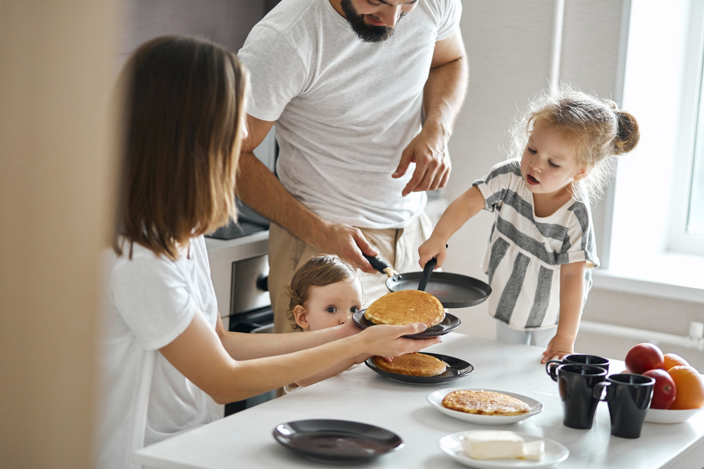 Family cooking pancakes in a kitchen